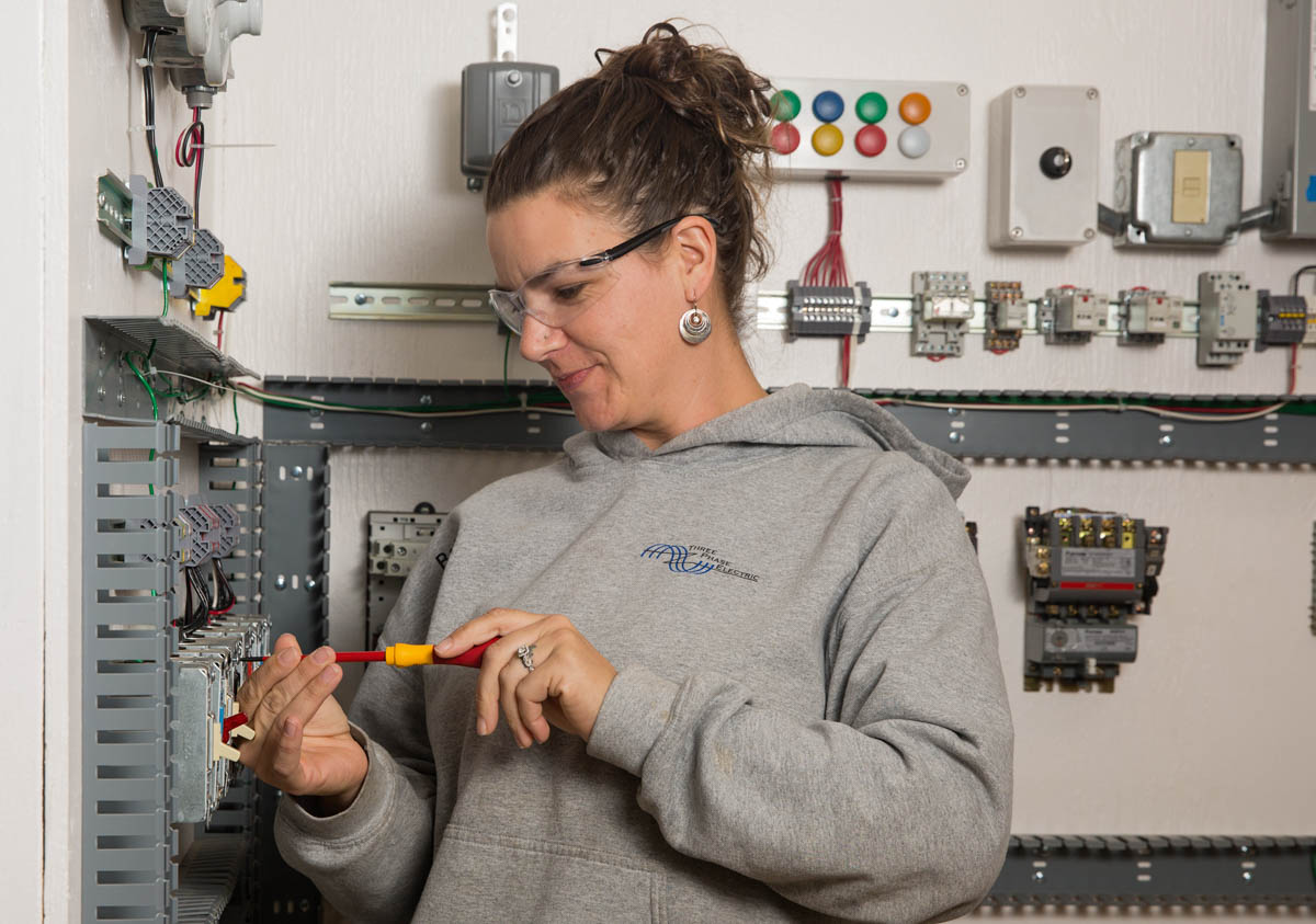Woman working on electrical panel