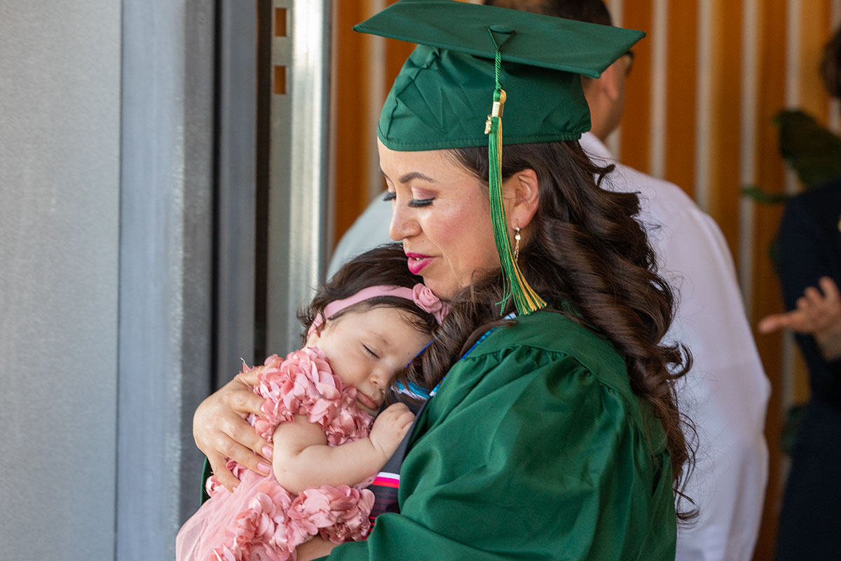 Female graduate holding a baby